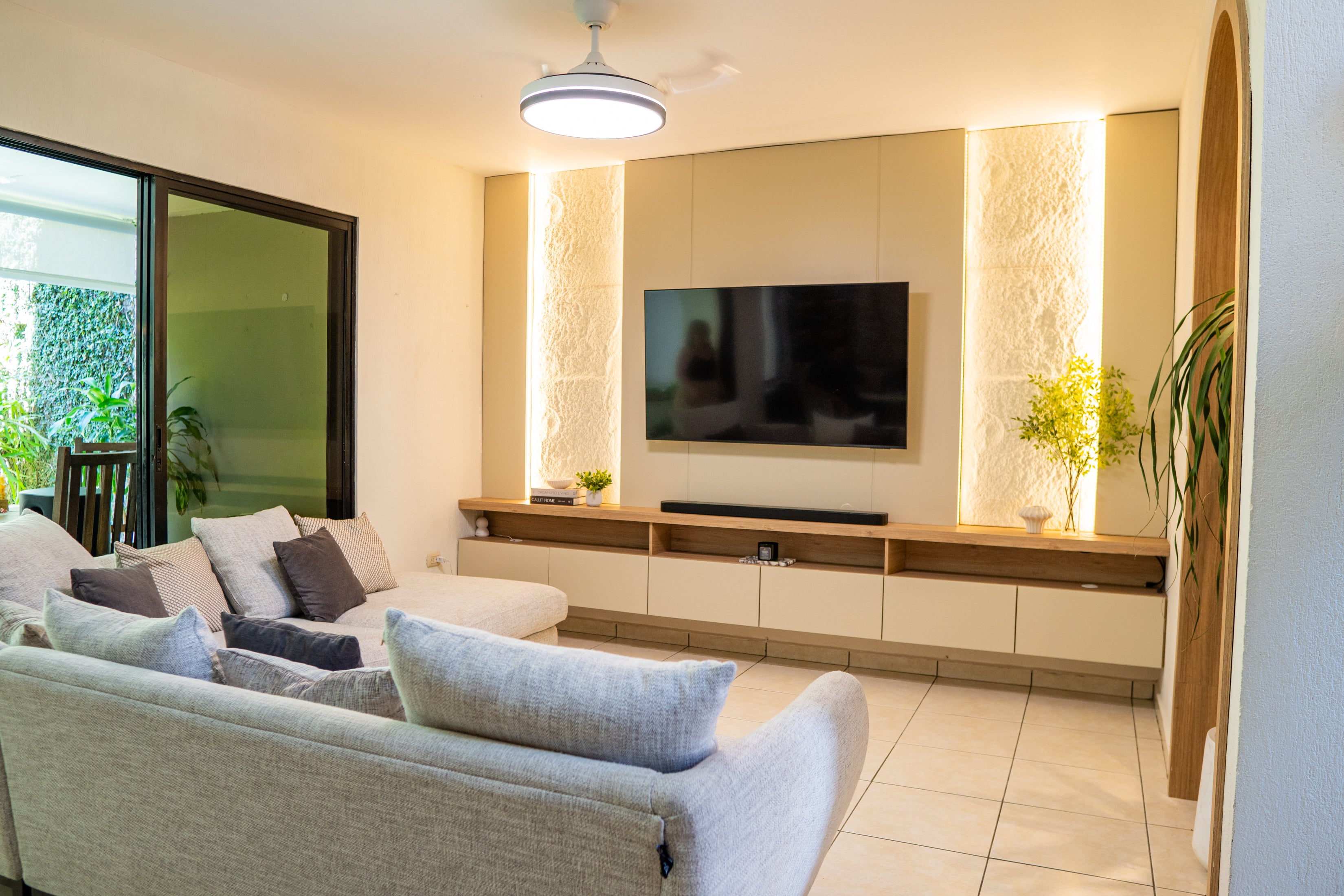 Miramar — sala con mueble de TV en madera e iluminación indirecta