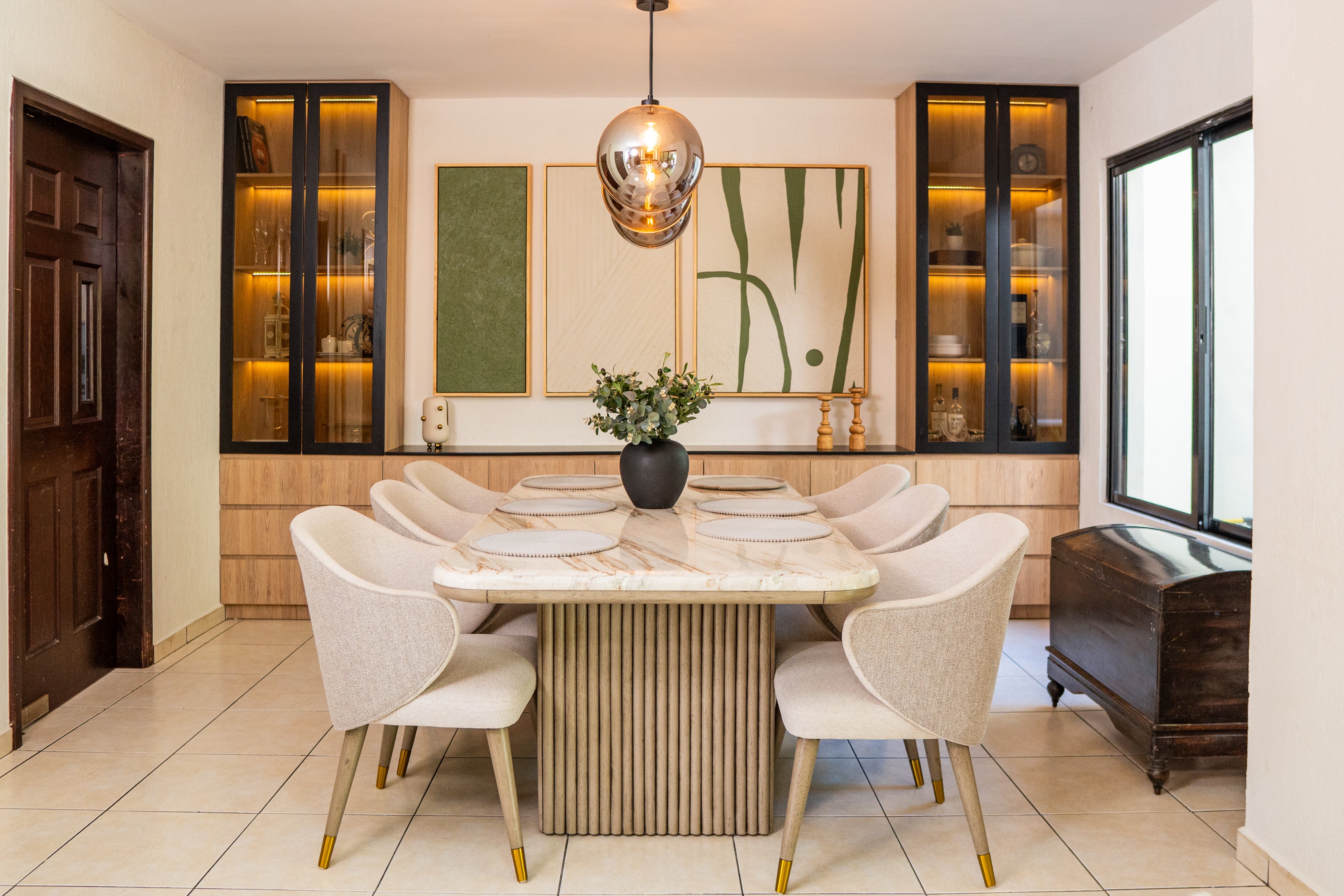 Miramar — comedor con mesa de mármol y vitrinas iluminadas en madera